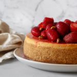 Strawberry and Pistachio topped ricotta cheesecake with tea towel.