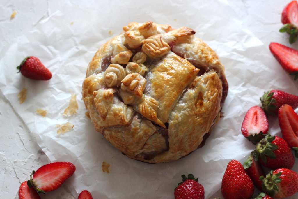 Puff pastry parcel with scattered strawberries.