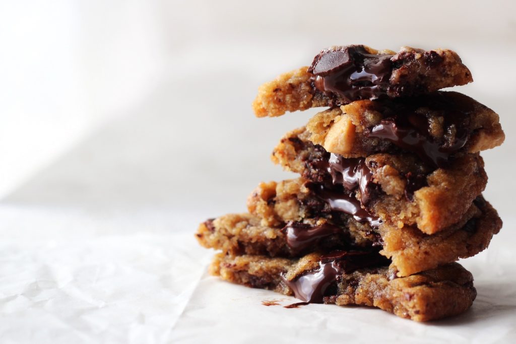 A stack of cookies with chocolate oozing out.